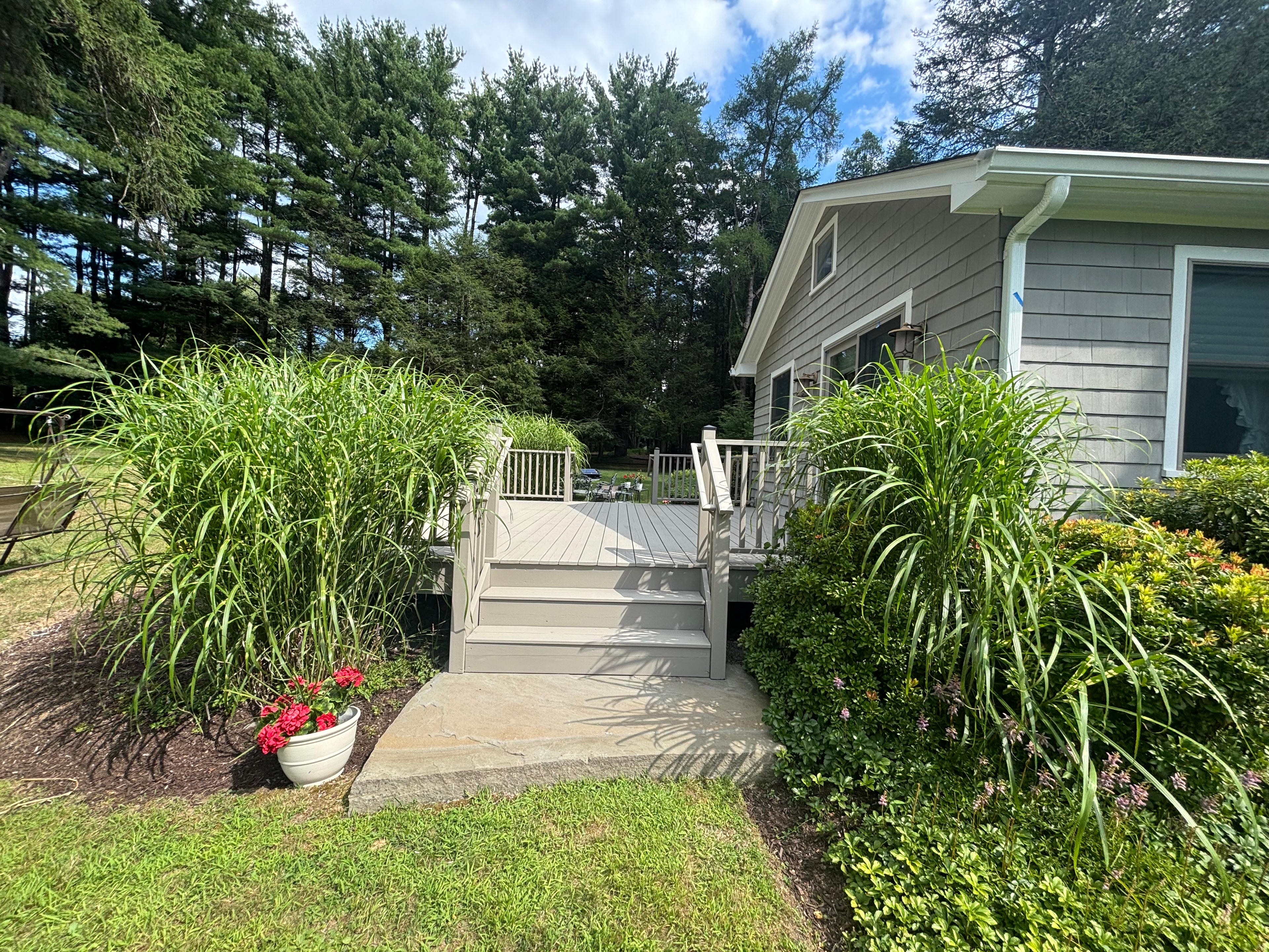 Elegant white deck with stairs and professional landscaping